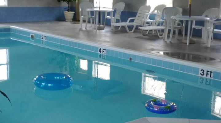 Outdoor resort pool with seating and umbrellas at Brook Pointe Resort Syracuse Indiana