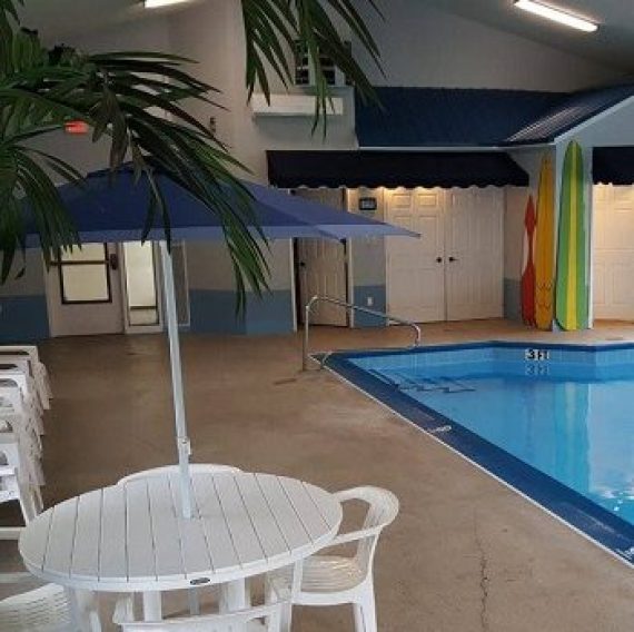 Indoor heated swimming pool with seating area at Brook Pointe Resort in Syracuse, Indiana