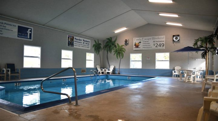 Outdoor resort pool with seating and umbrellas at Brook Pointe Resort Syracuse Indiana