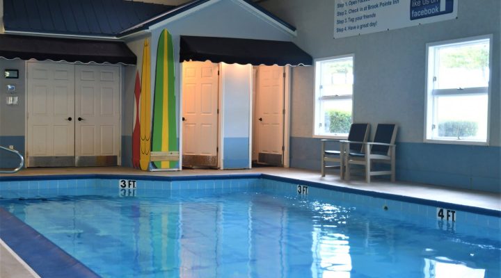 Outdoor resort pool with seating and umbrellas at Brook Pointe Resort Syracuse Indiana