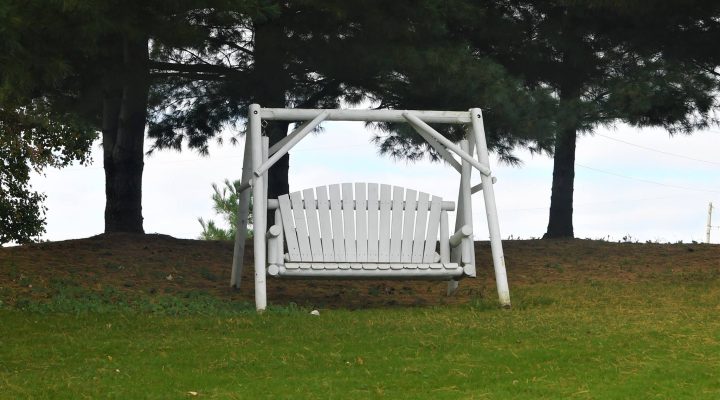 Wooden swing seating in the garden at Brook Pointe Resort